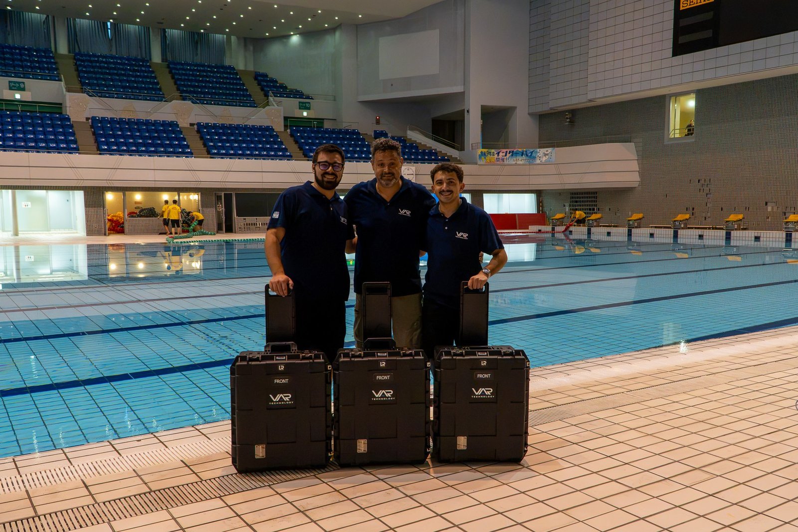 El equipo de Var Technology con sus tres valijas VAR junto a la pileta, en Chiba